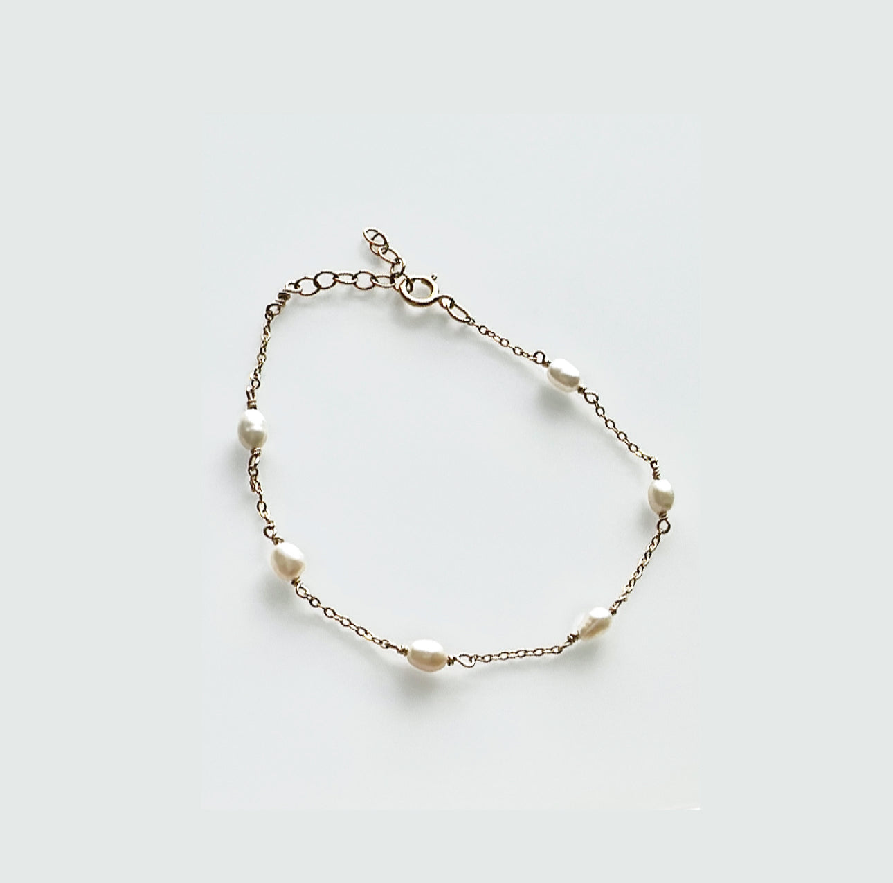 Gold-filled pearl bracelet on white background.