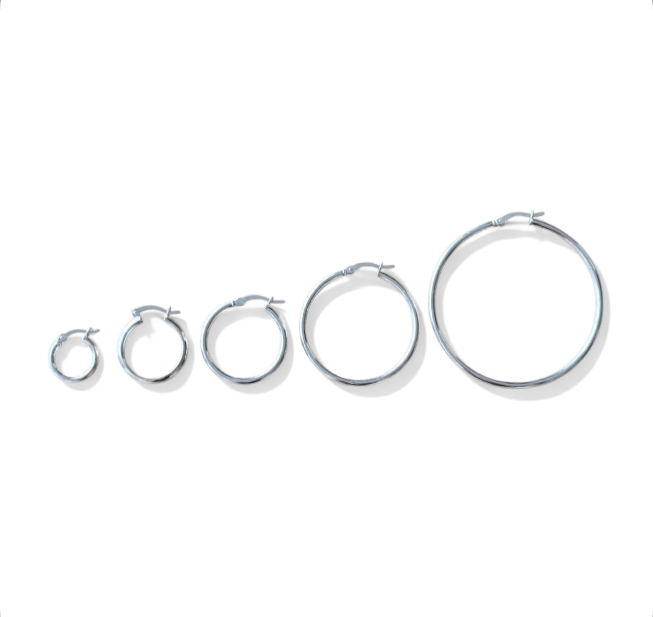 Set of silver hoop earrings in various sizes on a white background