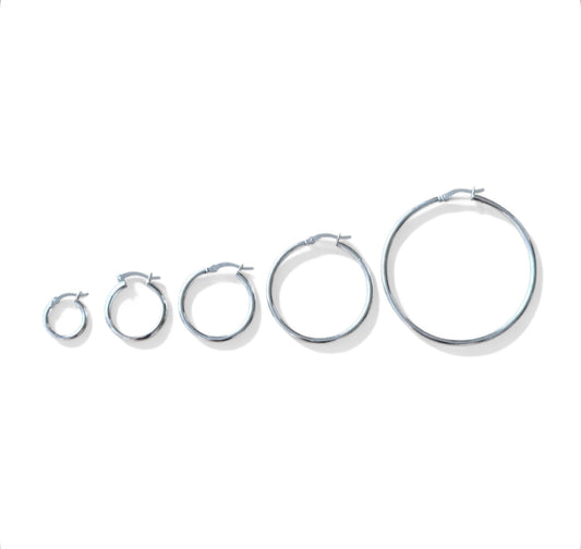 Set of silver hoop earrings in various sizes on a white background