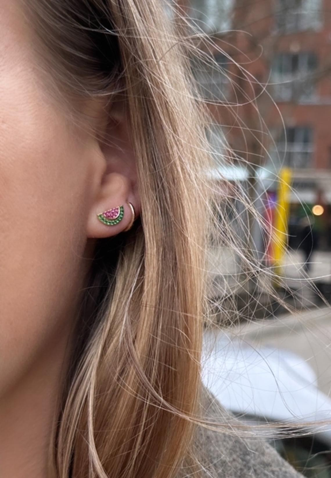 Watermelon stud earrings in sterling silver lifestyle shot on hand - Palestine relief fund jewellery