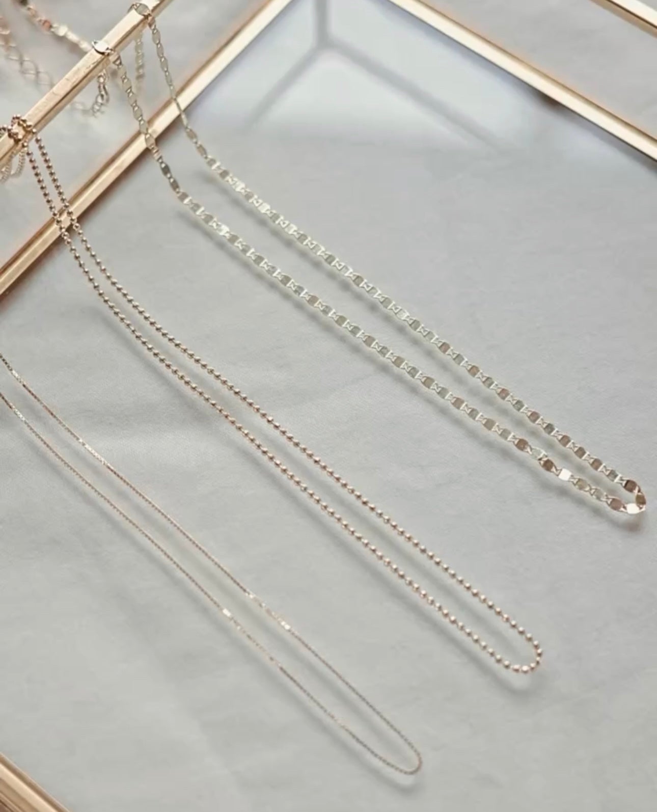 Close up of 10K gold box chain necklace showing ultra thin delicate paperthin links - solid gold swim safe
