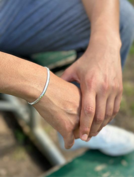 Close-up of hands holding each other with a blurred outdoor background