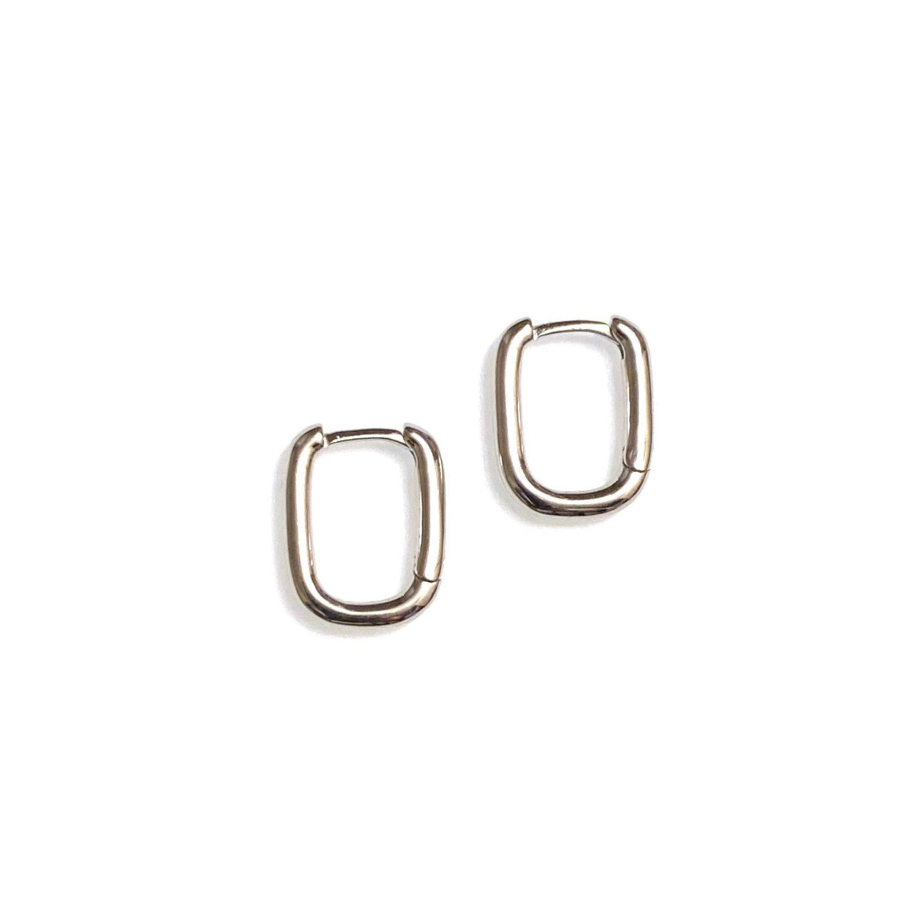 Close-up of petite rectangular hoop earrings showing sterling silver detail and minimalist shape
