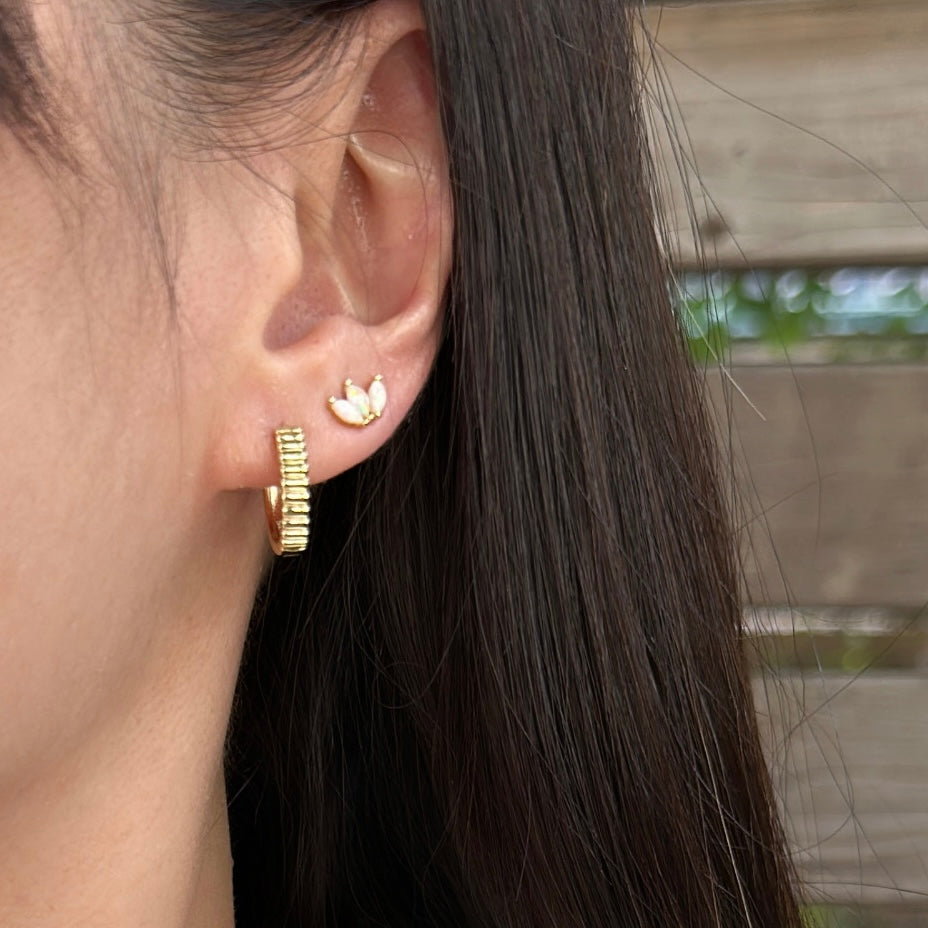 Close-up of ridged texture detail on gold plated hoop earrings