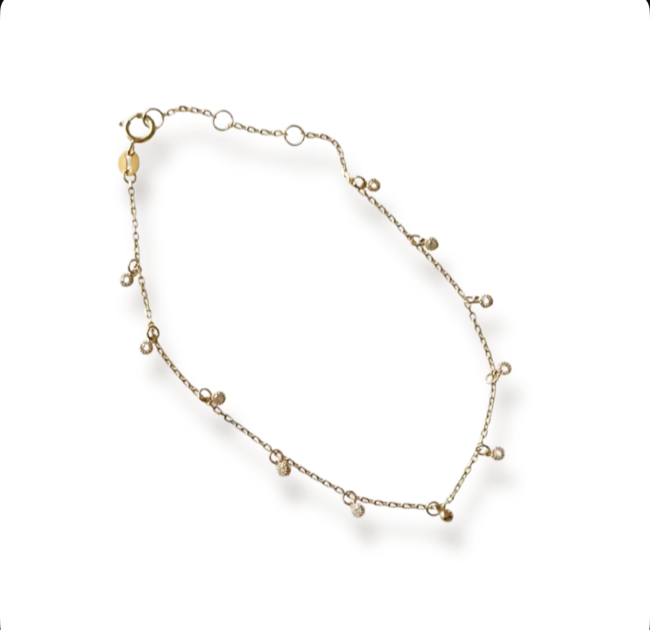Gold bracelet with small sparkly charms on a white background