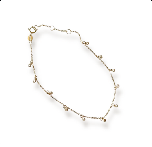 Gold bracelet with small sparkly charms on a white background