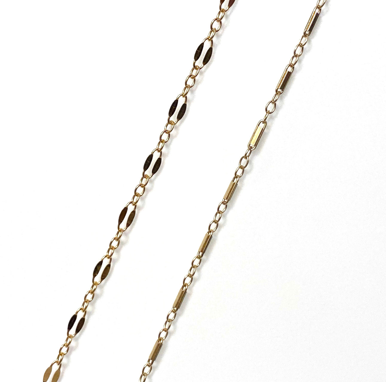 Two gold-filled chains, one a twin chain and the other a gold bar chain, against a white background.