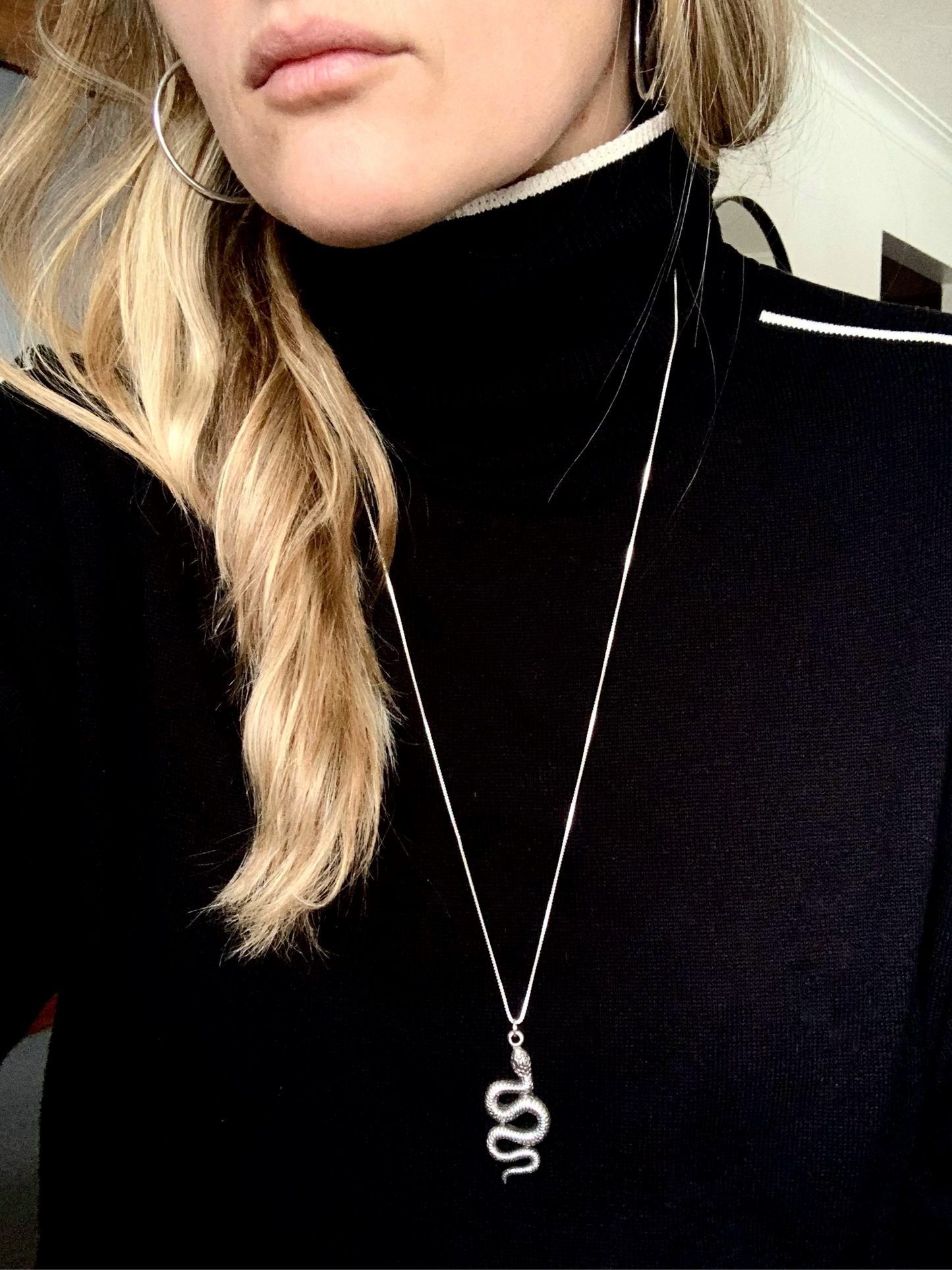 woman wearing snake necklace and black turtleneck