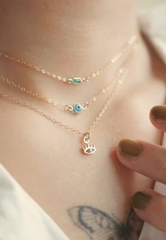 Teeny collection necklaces with solid gold pendants - emerald baguette and evil eye charms on gold-filled chains