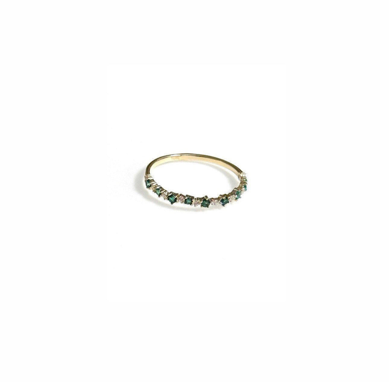 A dainty gold ring encrusted with little green and white cubic zirconia stones.