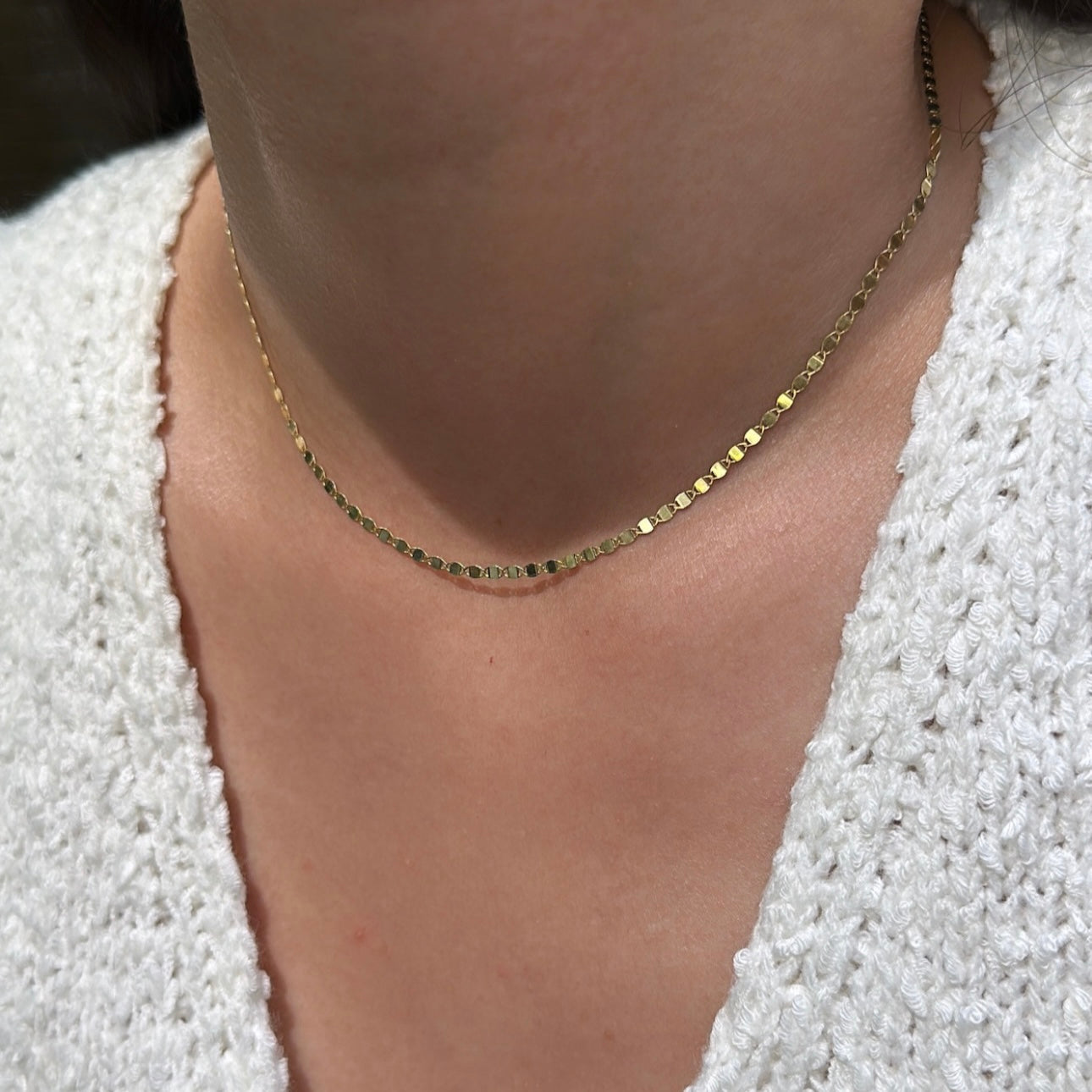 dainty valentino chain necklace on model wearing white sweater