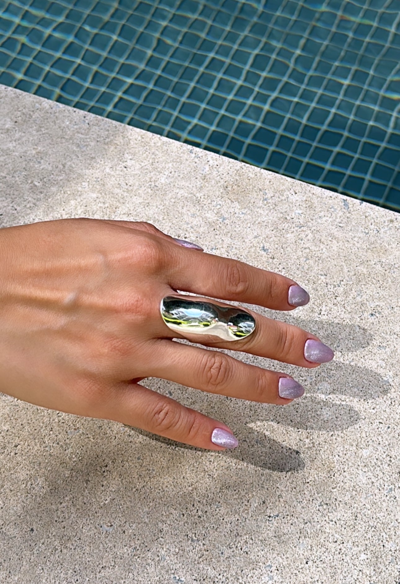 sterling silver full shield ring on hand by pool