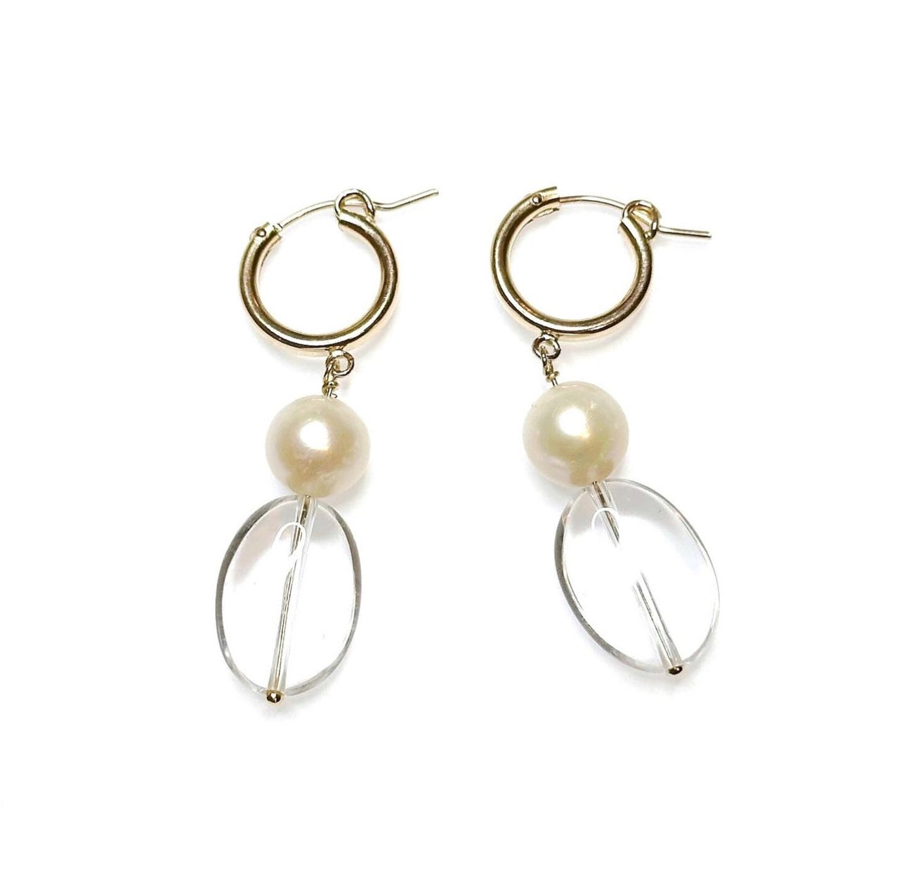 A pair of pearl earrings with clear quartz crystal accents and gold-filled hoops, displayed against a white background.