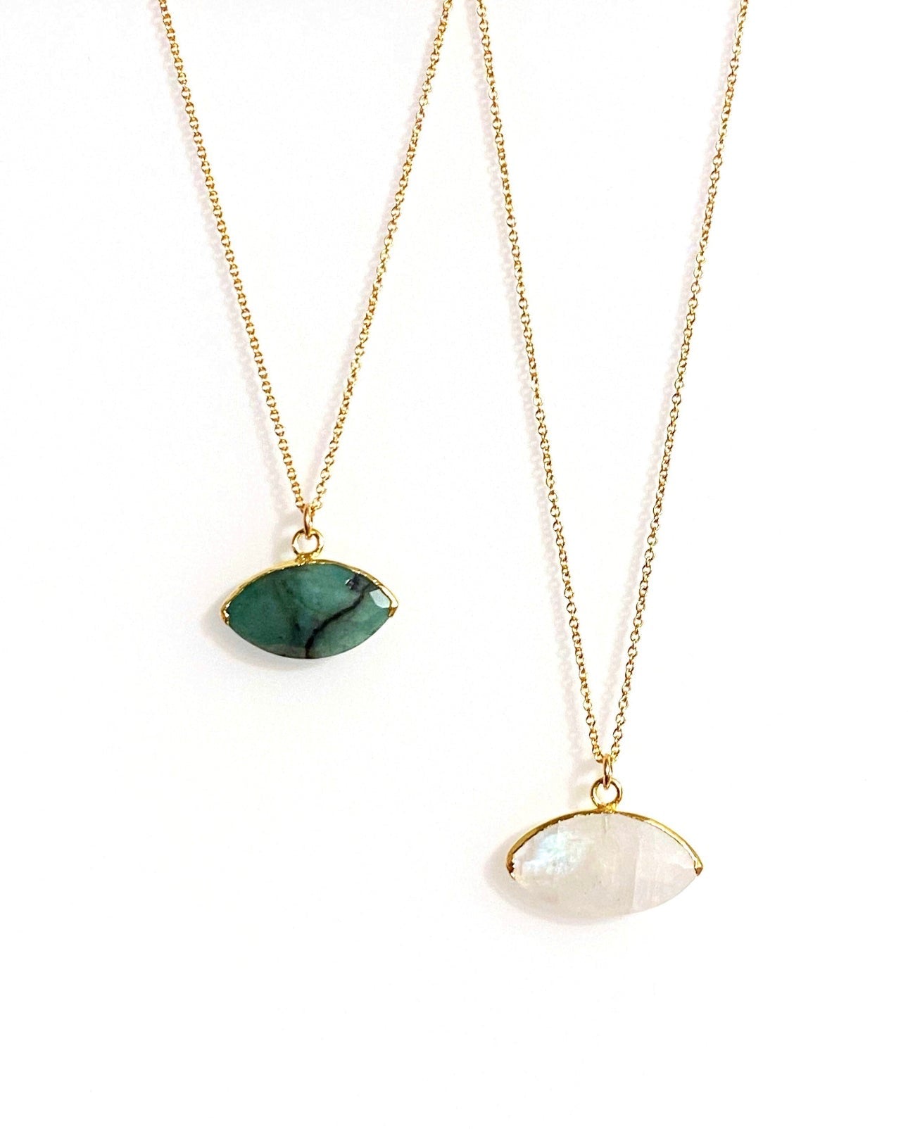 Two gold necklaces with gemstone pendants on a white background