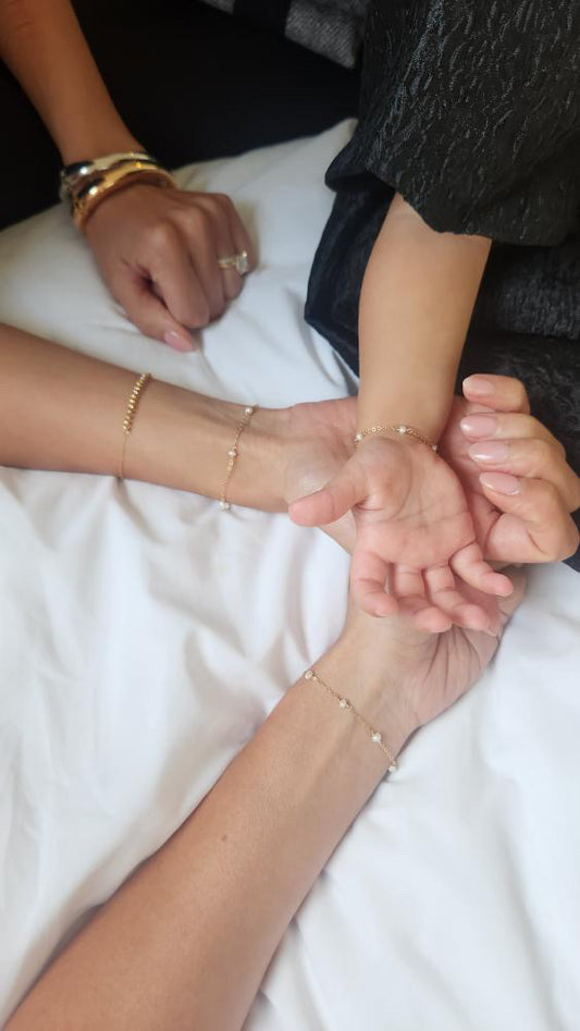 Three pairs of hands holding each other on a white surface