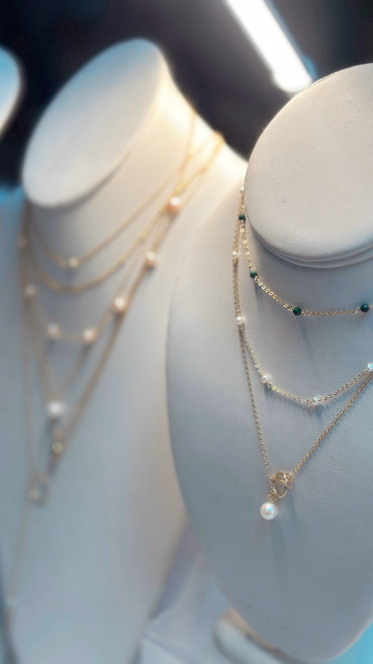 Staccato gemstone bracelet and necklace detail view showing 14K gold-filled chain with serpentine, sapphire, and malachite beads
