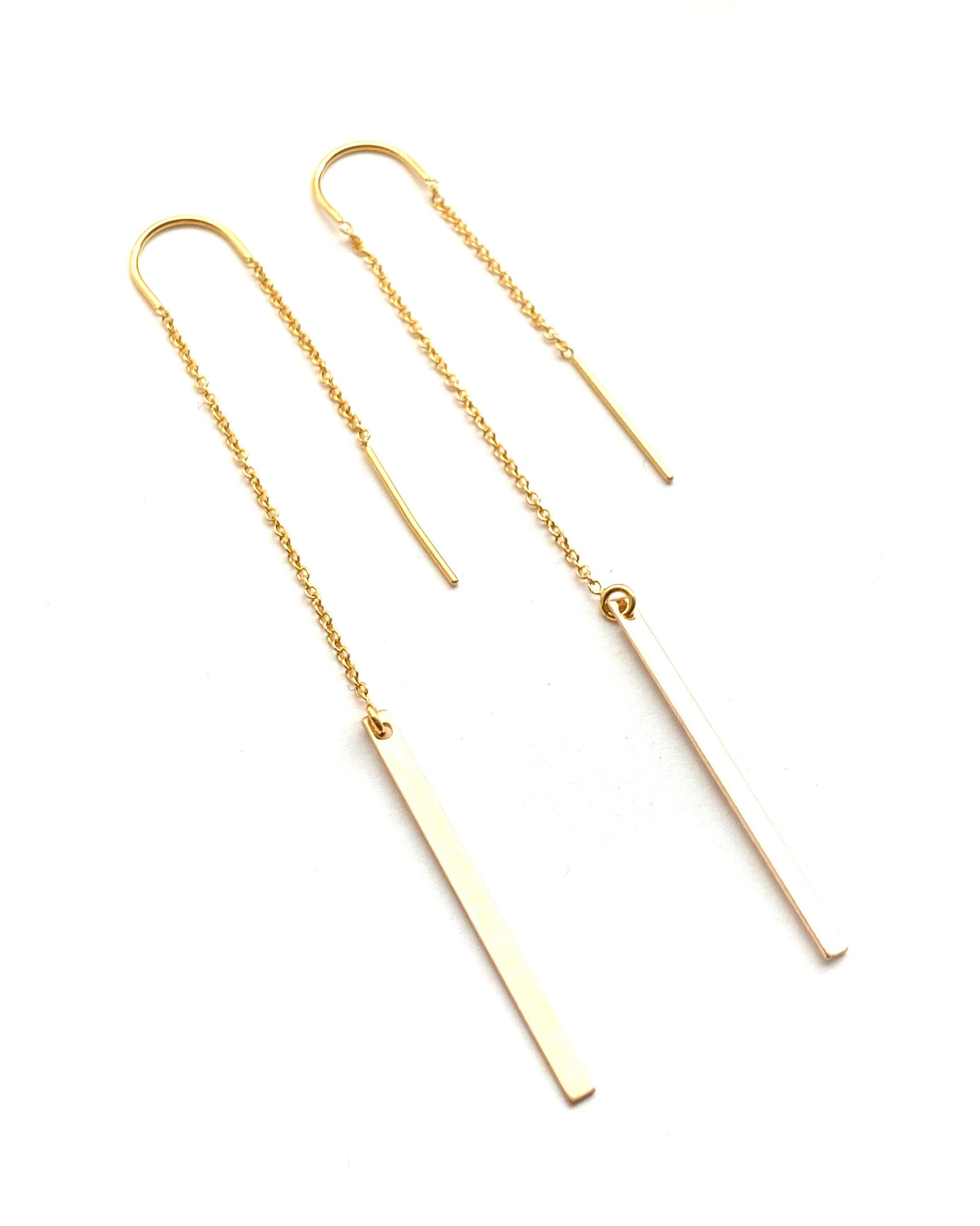Close-up of fixed U threader earrings showing minimalist bar and light-reflecting 14K gold-filled design