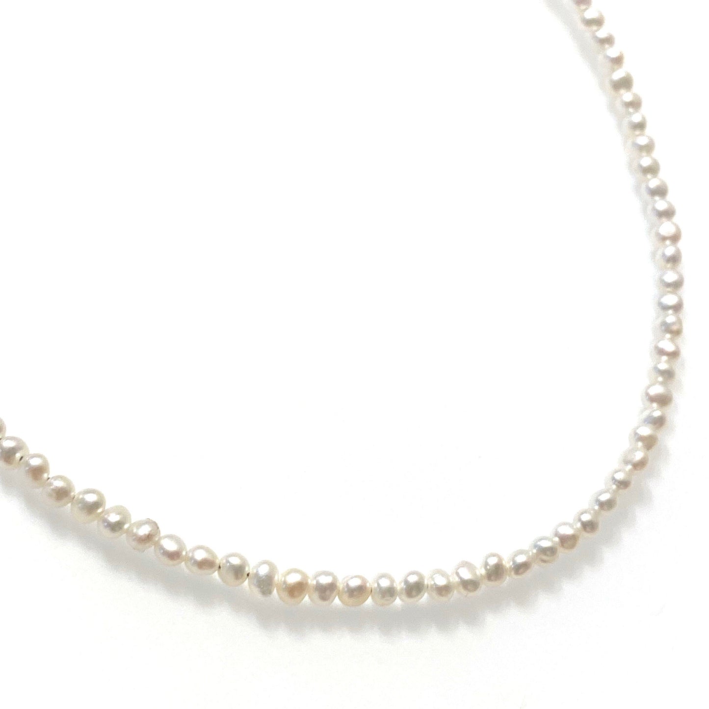 Close-up of baby freshwater pearl necklace showing natural pearly sheen and genuine undyed pearls