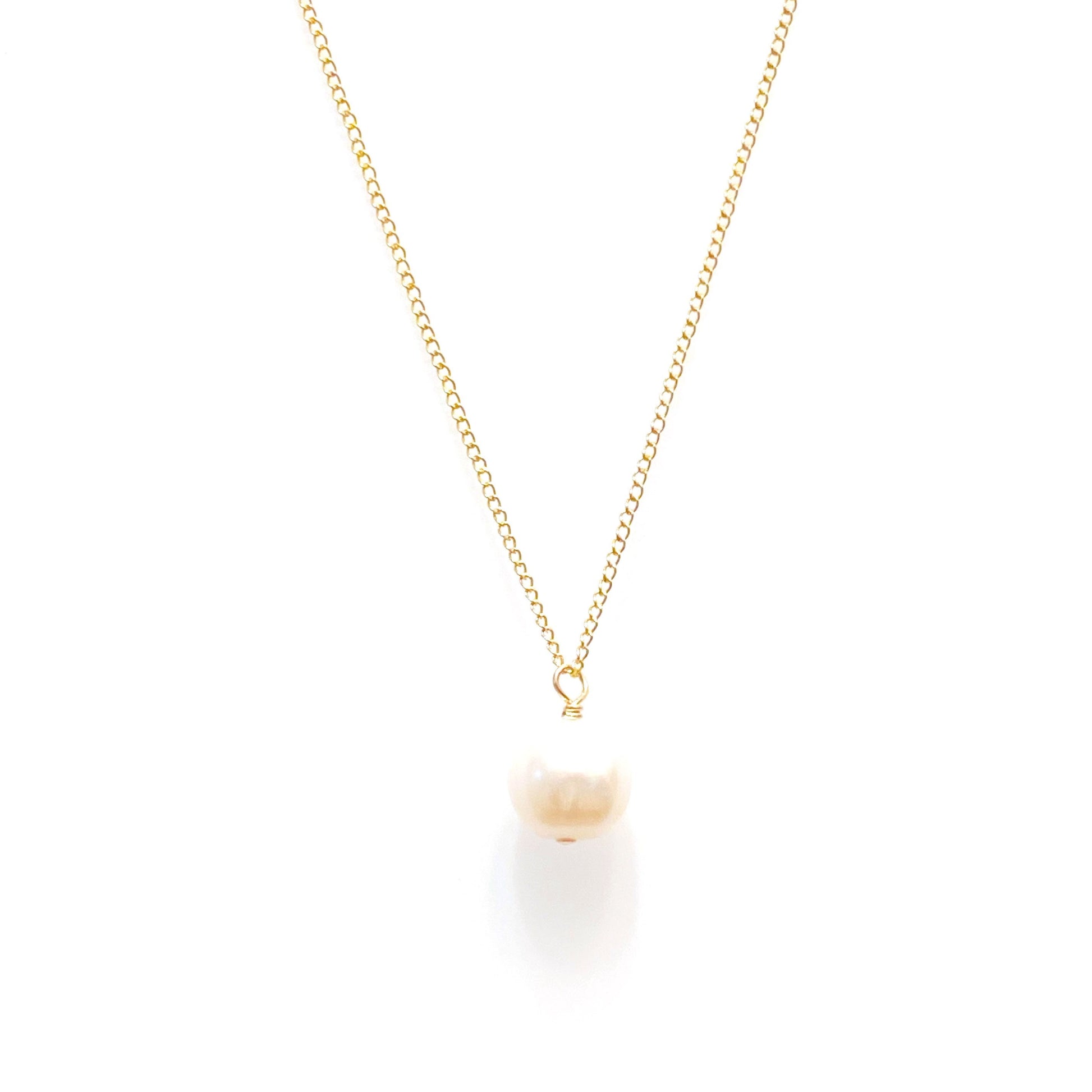 A minimalist pearl necklace with a gold chain and a single pearl pendant, presented on a plain background.