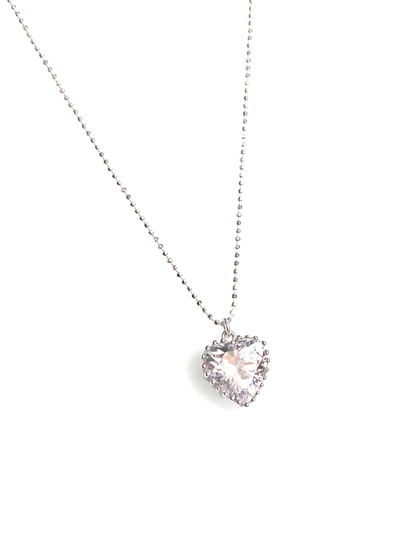 Close-up of sparkly cubic zirconia heart pendant on sterling silver ball chain showing shimmer and detail
