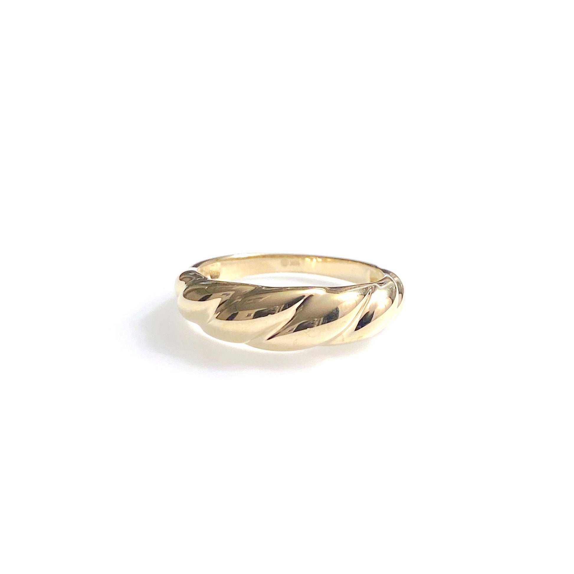 A gold ring with a fluffy, croissant-like design, displayed on a white background.