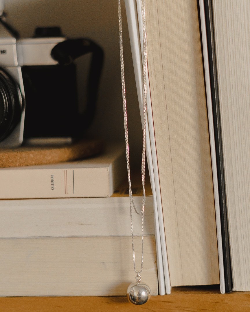 Chime ball necklace sterling silver - on bookcase