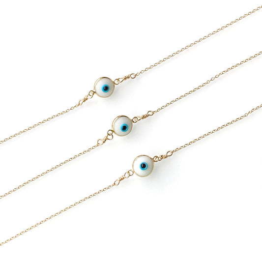 A set of evil eye bracelets in gold color, featuring small circular charms representing the evil eye on a chain.
