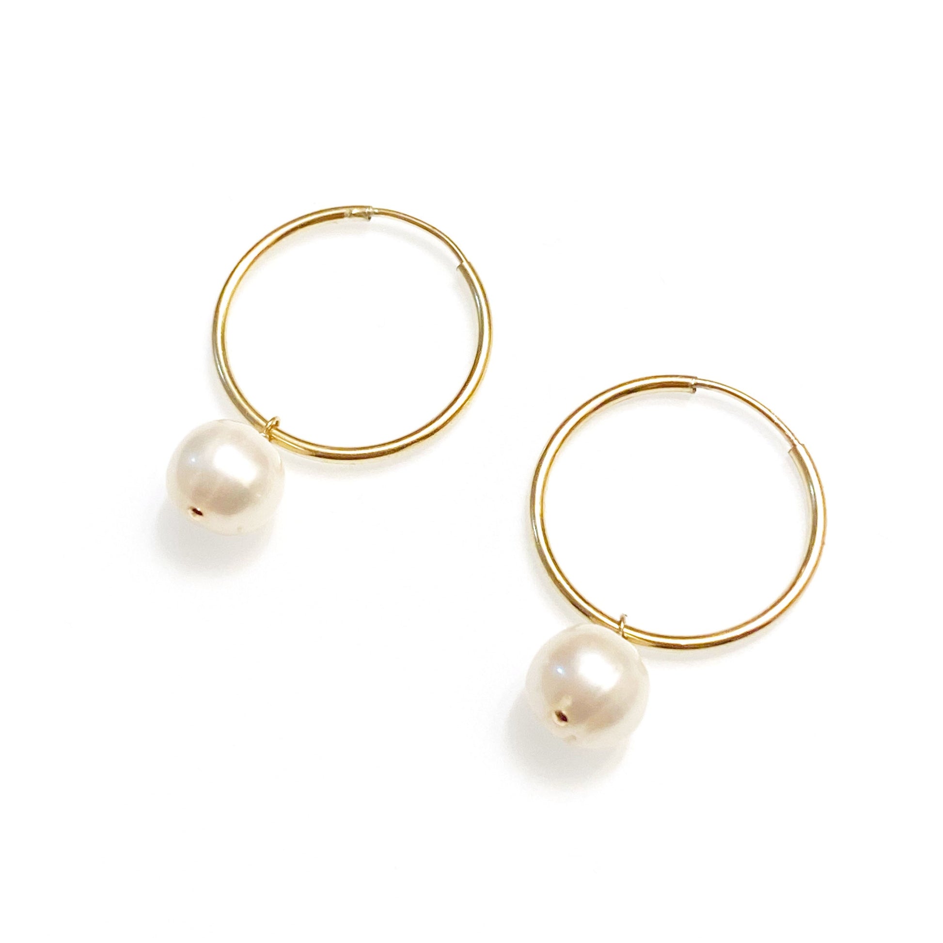 gold filled minimalist pearl earrings against white background