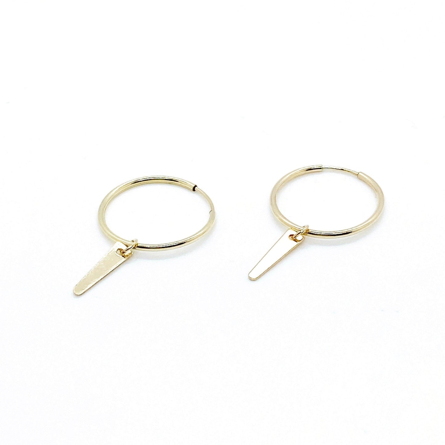 A pair of gold-filled minimalist charm hoop earrings on a white background.