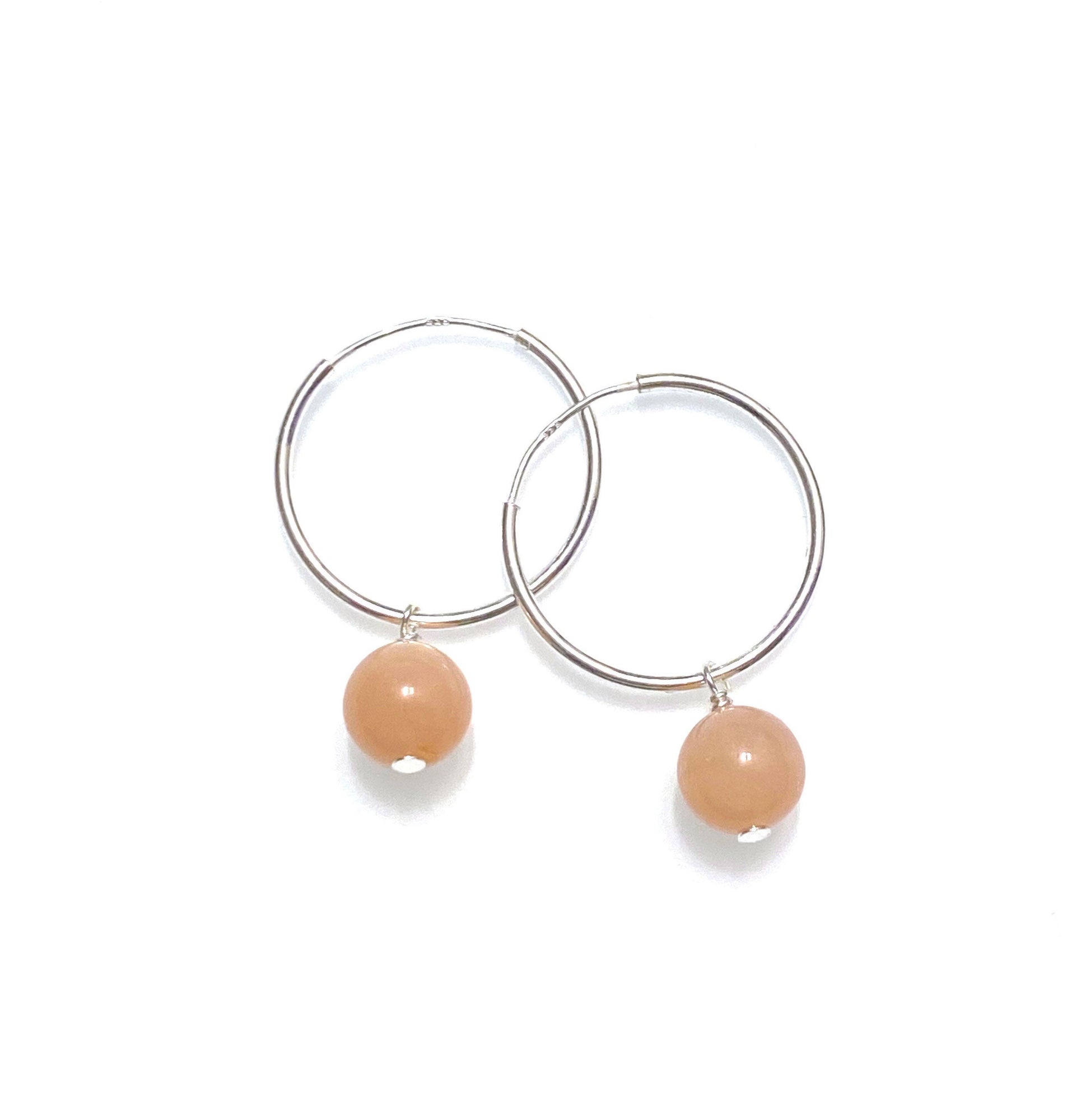 close up of peach moonstone on silver hoops