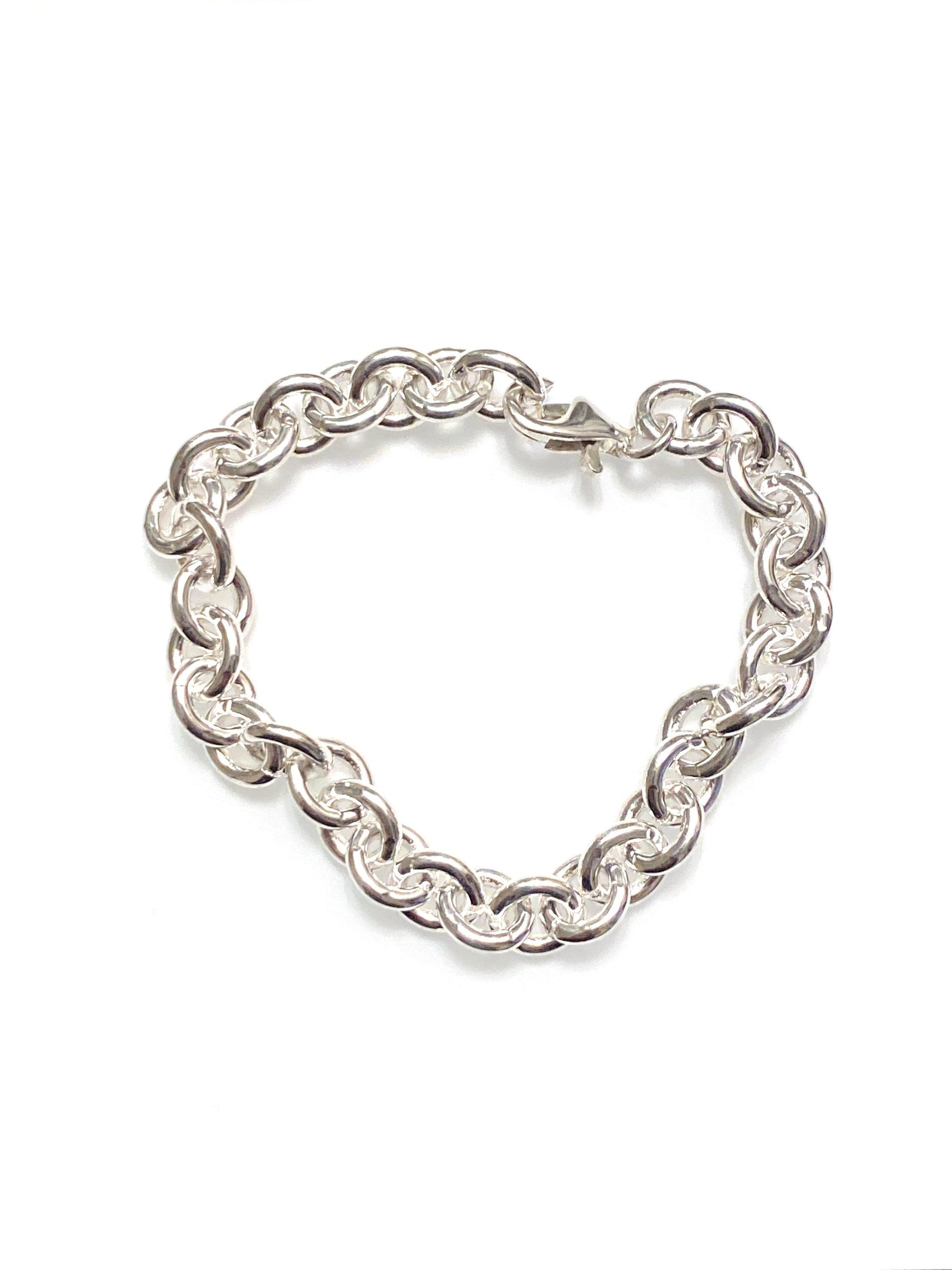 A chunky sterling silver anchor chain bracelet laid out in a loop on a white background.