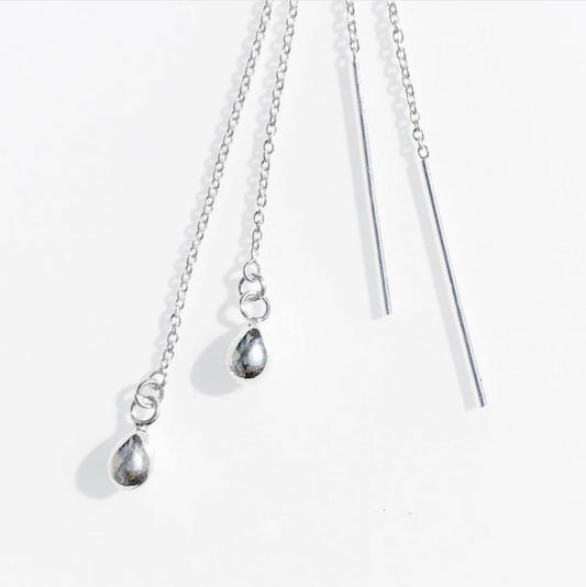 A set of sterling silver threader earrings with raindrop, art deco, star, and moon designs against a white background.